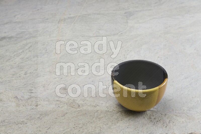 A multicolored pottery bowl on grey marble background