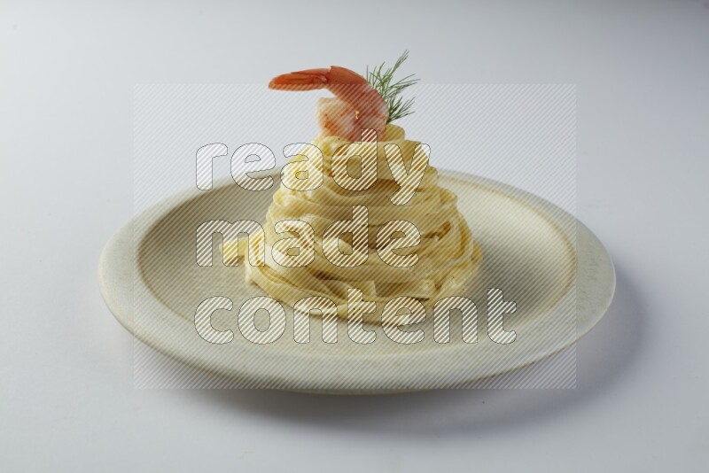 Fettuccini white sauce pasta with shrimp in a white plate on a white background