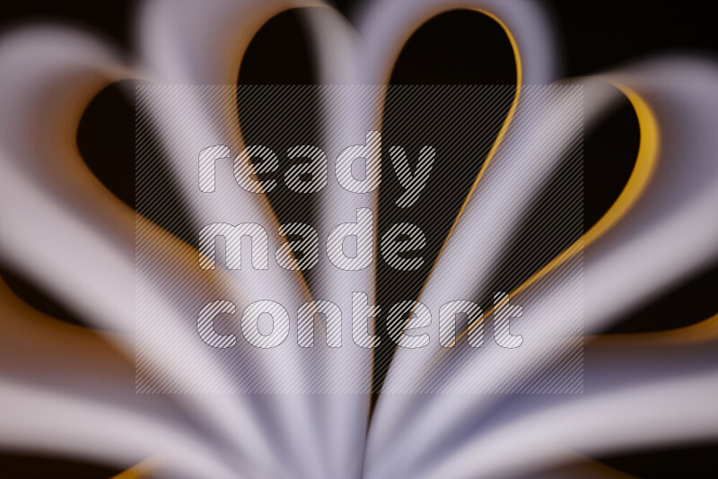 An abstract art piece displaying smooth curves in white and yellow gradients created by colored light