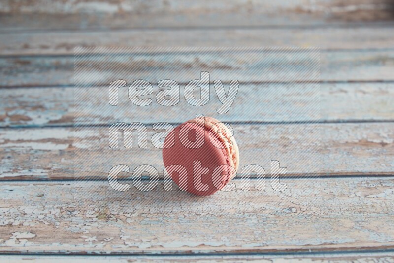 45º Shot of Pink Litchi Raspberry macaron on light blue wooden background