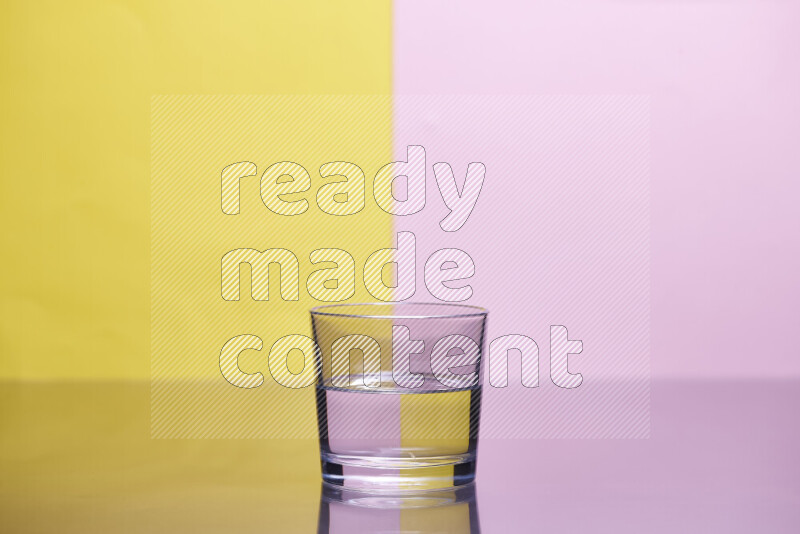 The image features a clear glassware filled with water, set against yellow and rose background