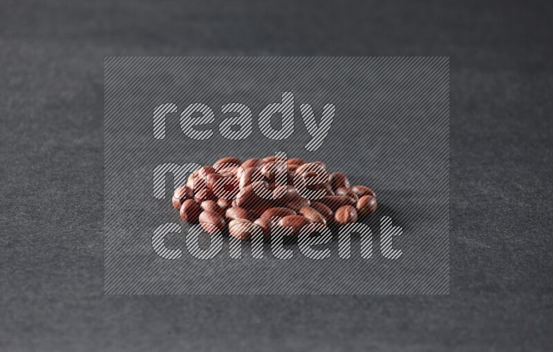 A bunch of red skin peanuts on a black background in different angles