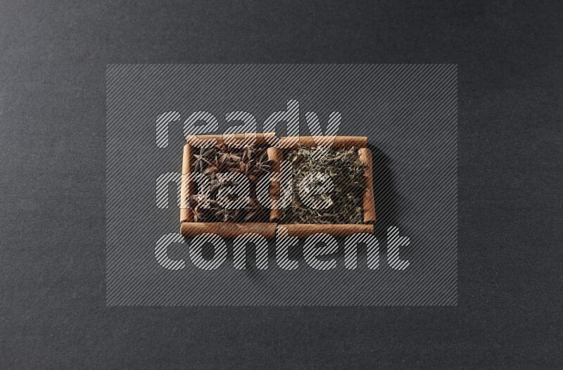 2 squares of cinnamon sticks full of star anise and dried basil on black flooring