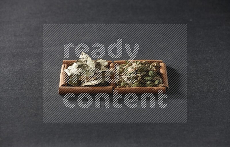 2 squares of cinnamon sticks full of cardamom and bay laurel leaves on black flooring