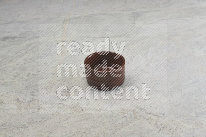 A brown pottery bowl on grey marble background