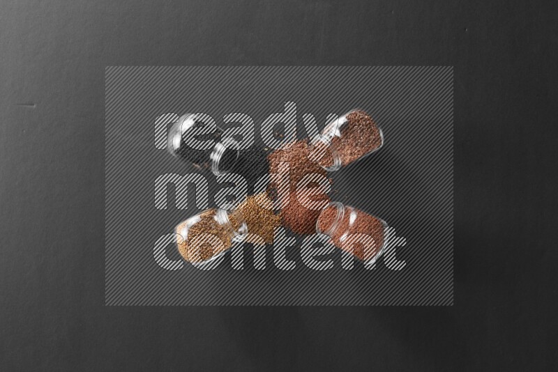 حبة البركة و حبوب الخردل وحبوب الكتان وحب الرشاد في أوعية زجاجية علي خلفية سوداء