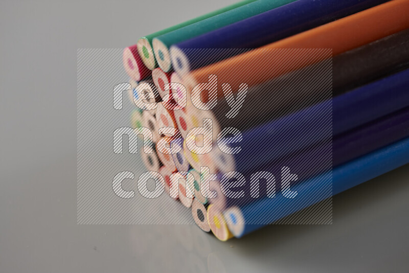 An array of colored pencils on grey background