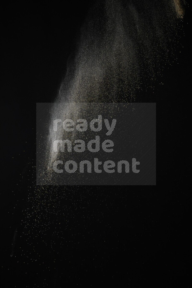 A side view of brown powder explosion on black background
