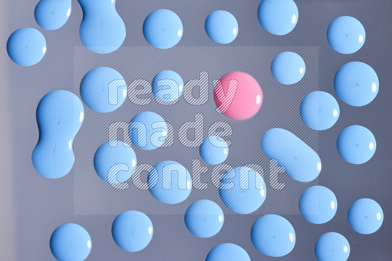 لقطات مقربة لقطرات من اللون الوردي والأزرق على الخلفية