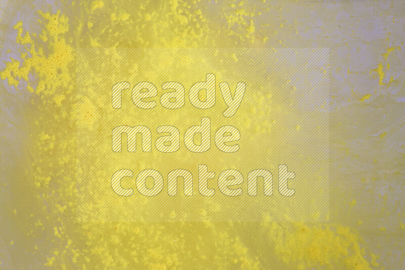 The image captures a dramatic splatter of yellow paint over a white backdrop