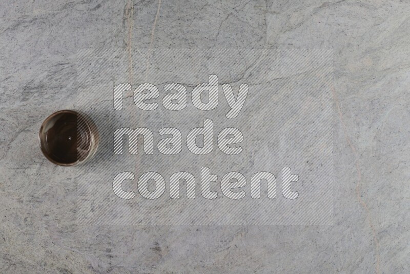 كأس فخاري متعدد الألوان على خلفية من الرخام الرمادي