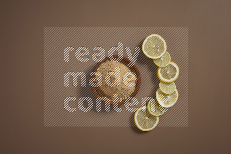 Two bowls full of honey and ground ginger with some of citrus fruits such as lemon and orange on a beige background