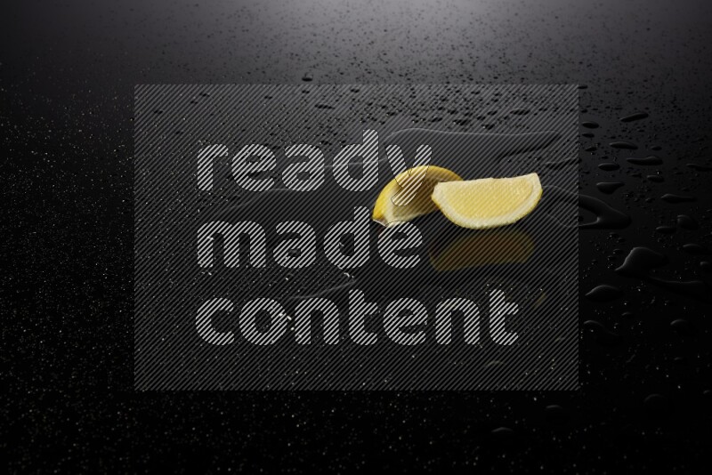 Lemon wedges with water drops, and droplets on black background