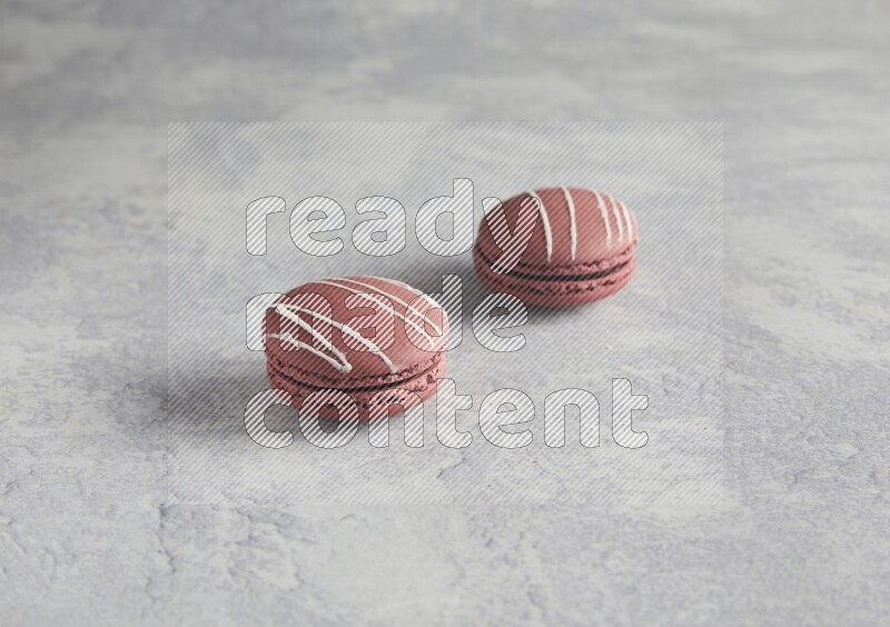 45º Shot of two Red Poppy Flower macarons on white  marble background