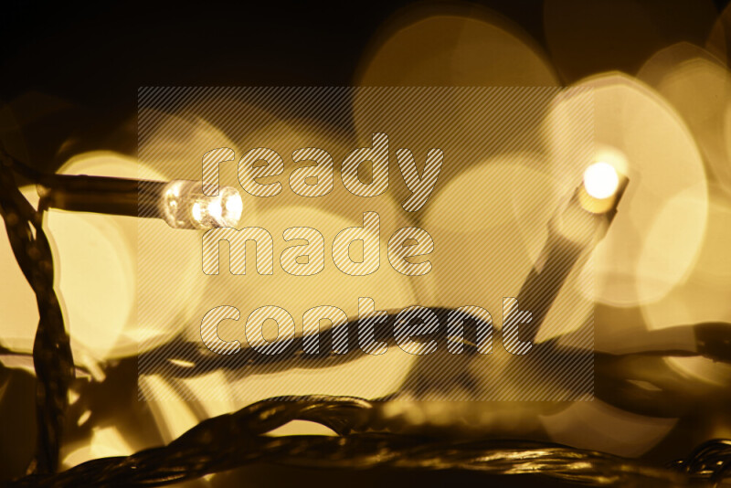 Light bulbs glowing against backdrop of golden bokeh