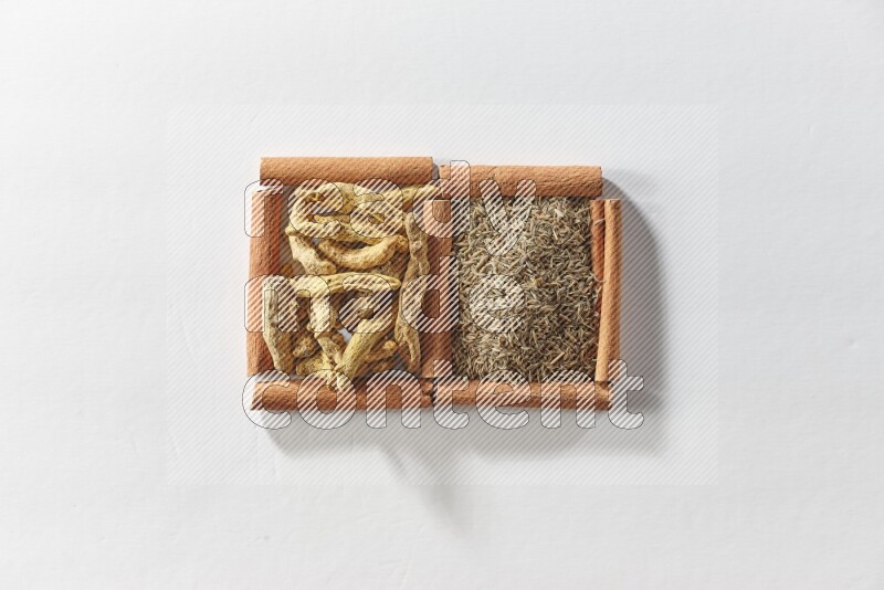 2 squares of cinnamon sticks full of cumin and turmeric fingers on white flooring