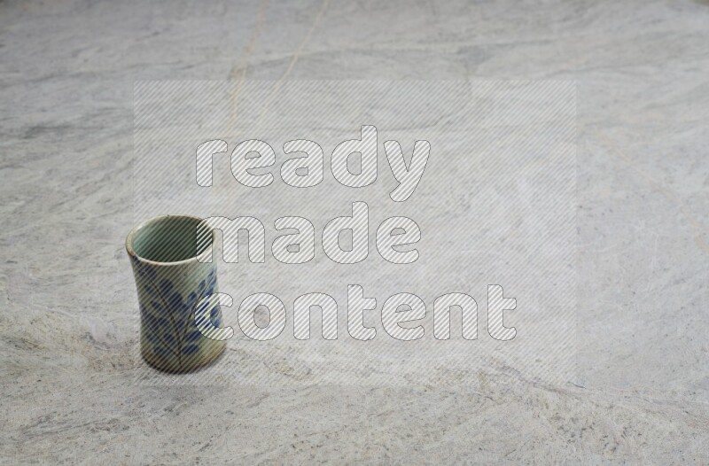 A multicolored pottery Cup on grey marble background