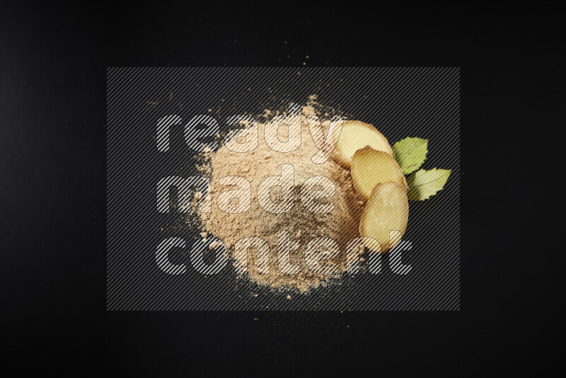 A bunch of ground ginger powder on black background
