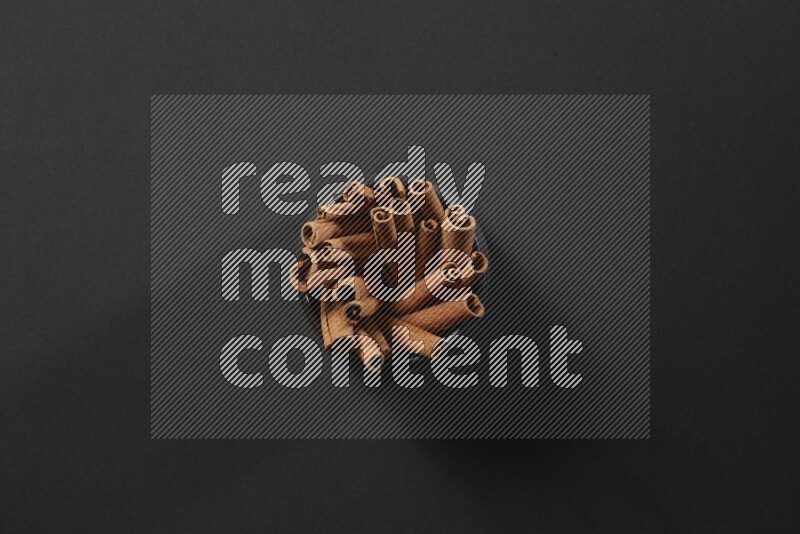 Cinnamon sticks in a black bowl on a black background in different angles