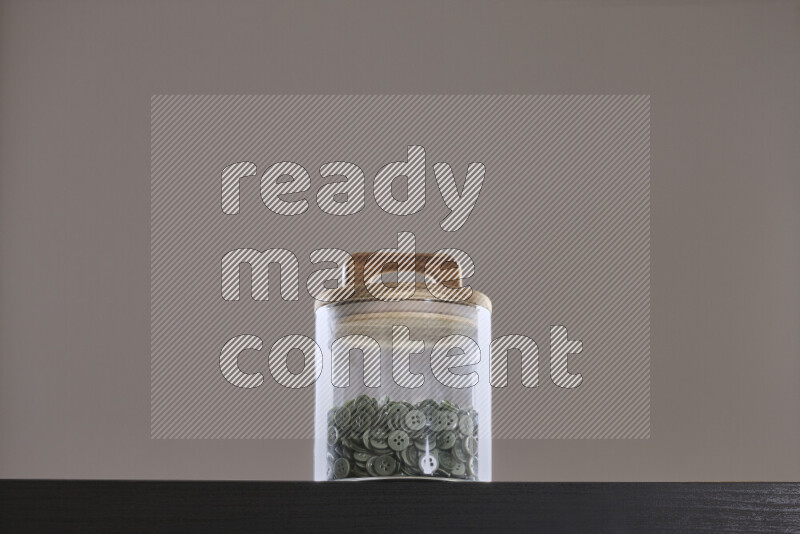 أزرار متنوعة في وعاء زجاجي علي خلفية سوداء