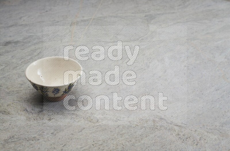 A multicolored pottery bowl on grey marble background