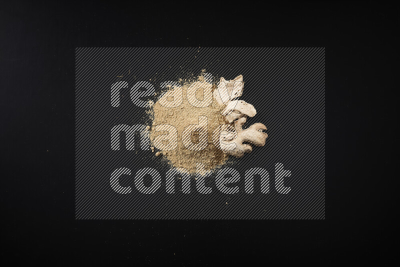 A bunch of ground ginger powder on black background