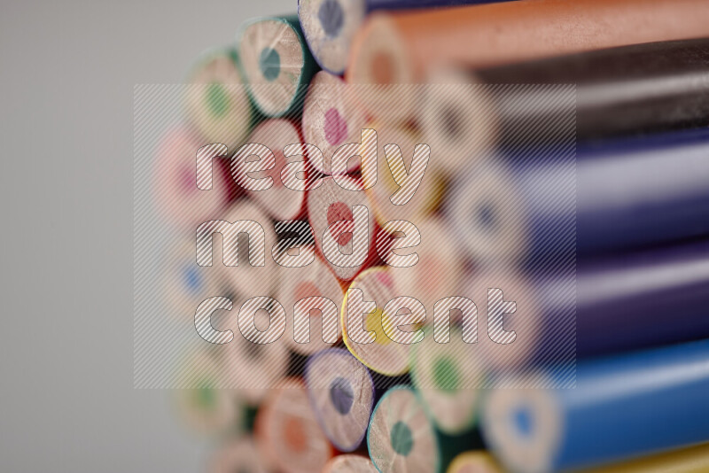 An array of colored pencils on grey background