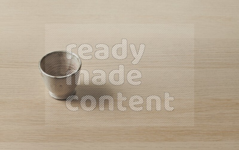 A pottery cup on light wooden background