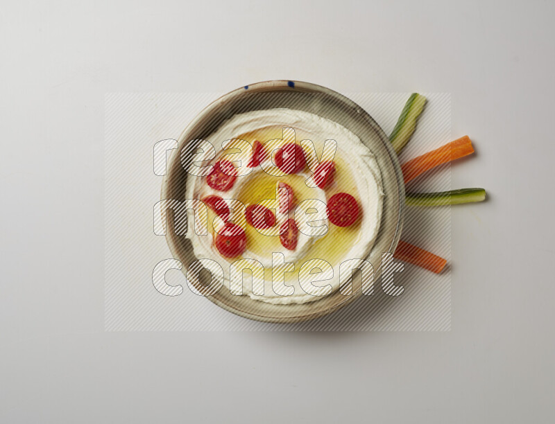 Lebnah garnished with cherry tomato in a grey pottery plate on a white background