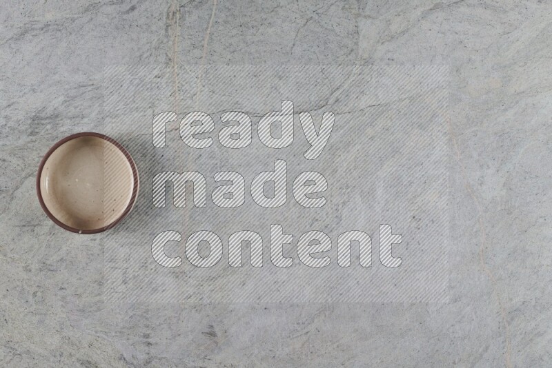 وعاء فرن فخاري متعدد الألوان على خلفية من الرخام الرمادي