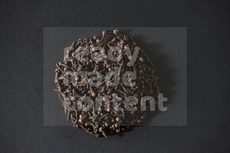 Cloves in a circle shape on a black flooring