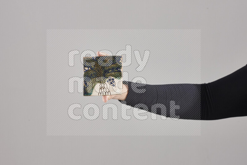 A woman in black abaya holding different pottery essentials in different positions