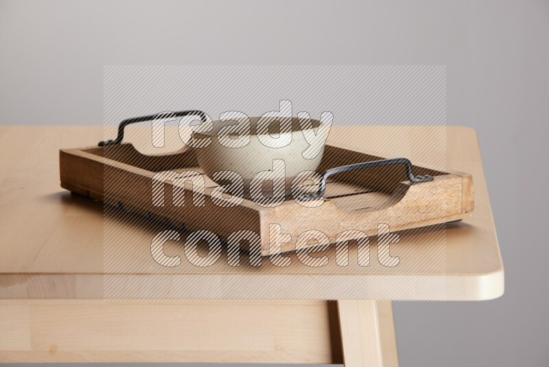 multi colored  bowl on a light colored rectangular wooden tray with handles