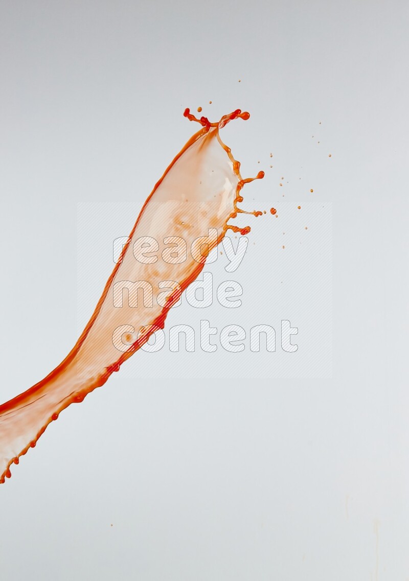 Orange liquid splash and drops on white background