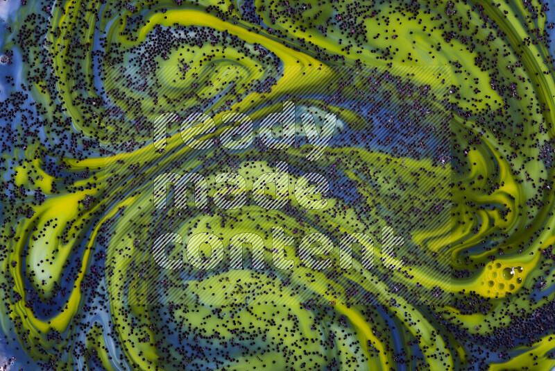 A close-up of sparkling purple glitter scattered on swirling blue and yellow background