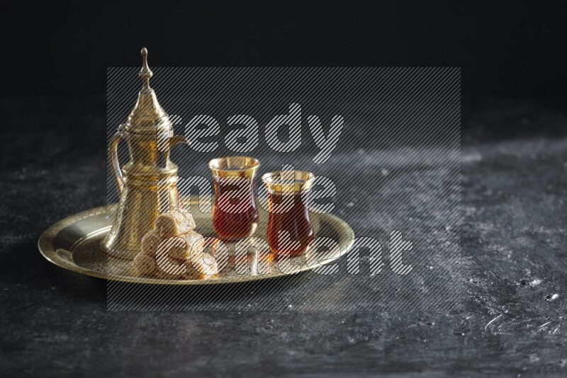 Golash with a drink on a metal tray in a dark setup