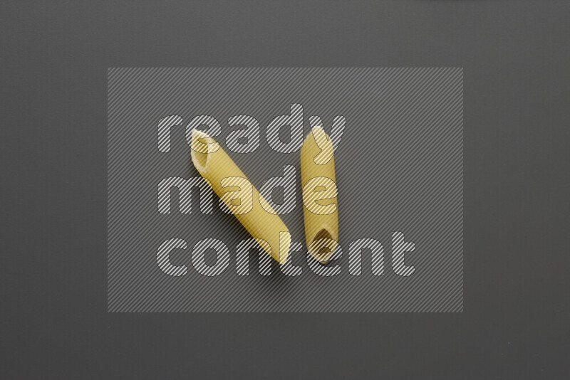 Penne pasta on grey background