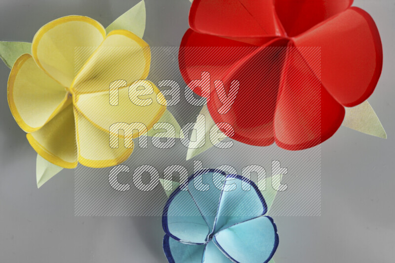 Origami flower on grey background