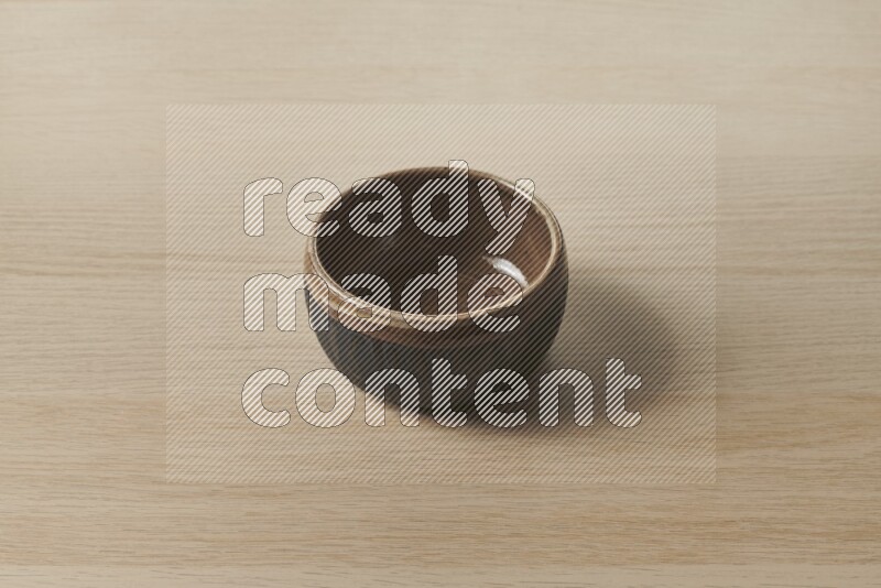 A multicolored pottery bowl on light wooden background