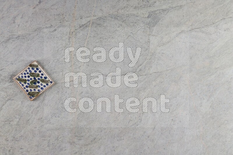 A decorative pottery coaster on grey marble background