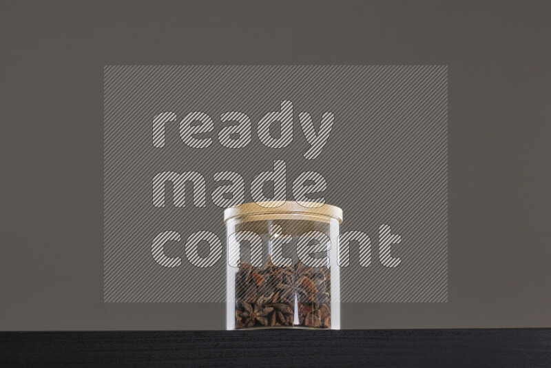 Star anise in a glass jar on black background