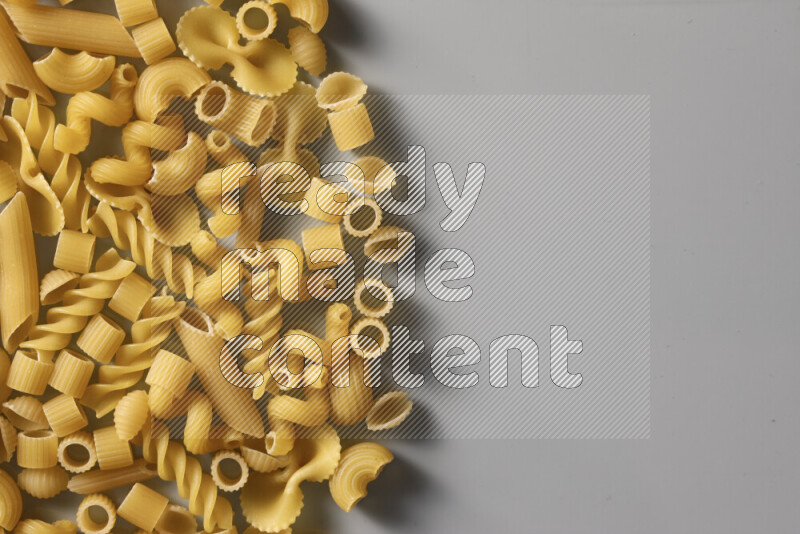 Different pasta types on light blue background