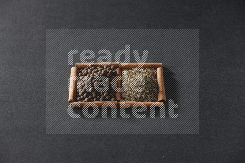 2 squares of cinnamon sticks full of cumin and allspice on black flooring