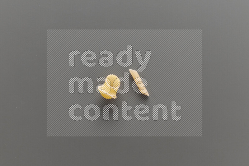 Pipe pasta with other types of pasta on grey background