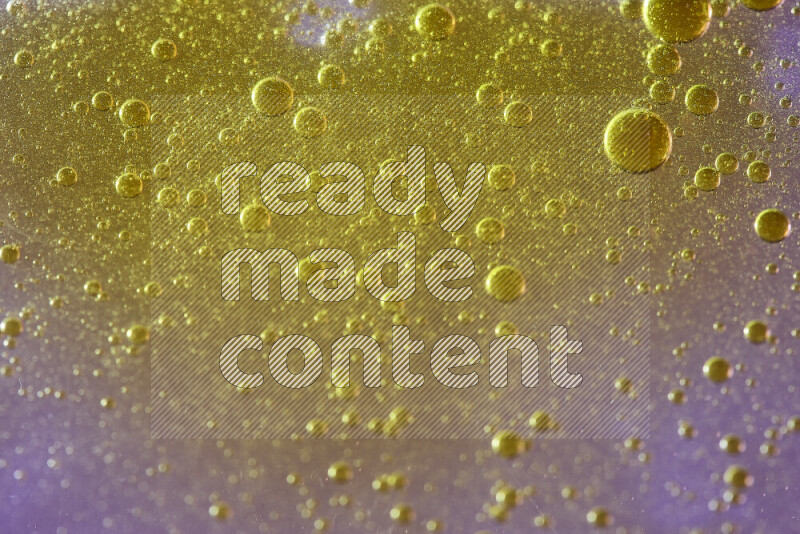 لقطات مقربة لقطرات ألوان مائية صفراء على سطح الزيت على خلفية وردية