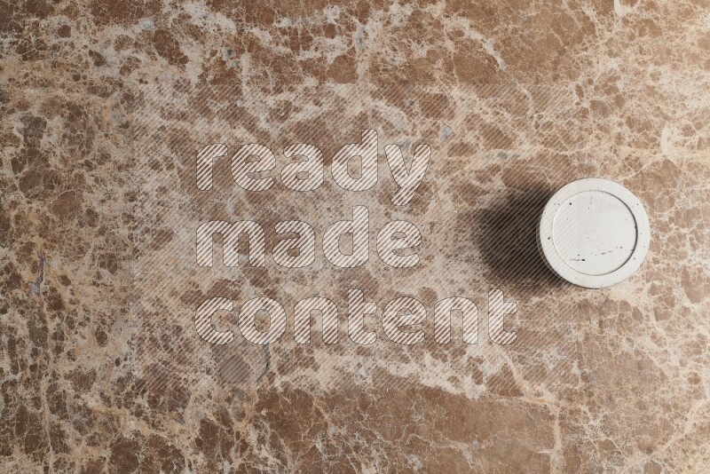 A pottery cup on beige marble background