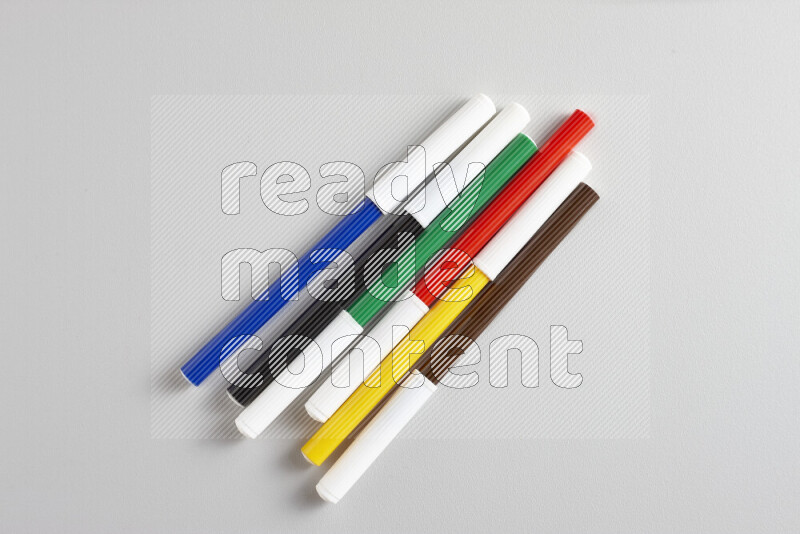 An arrangement of coloring pens in different colors on grey background