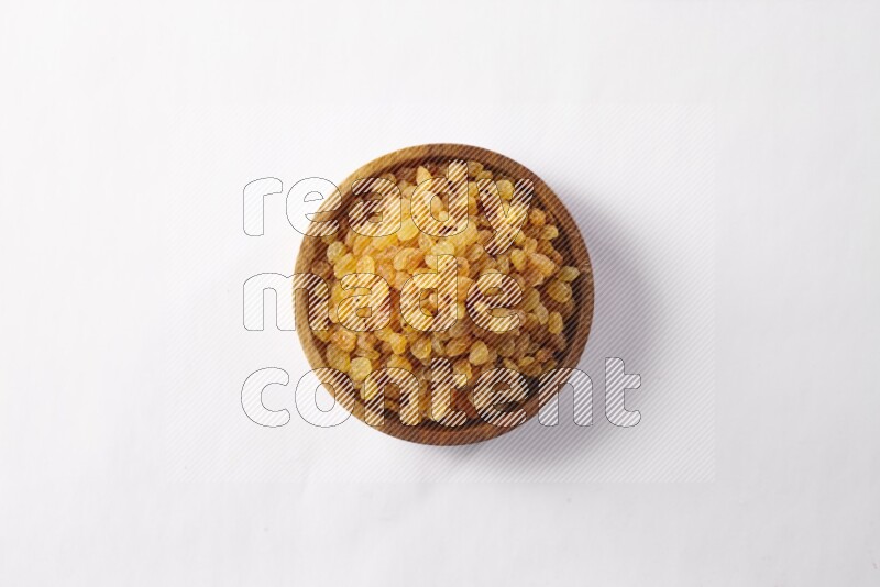 Raisins in a wooden bowl on white background