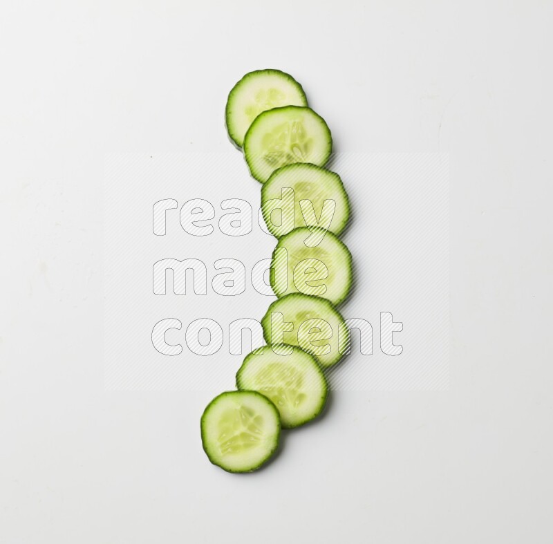 Multiple cucumber slices on white background