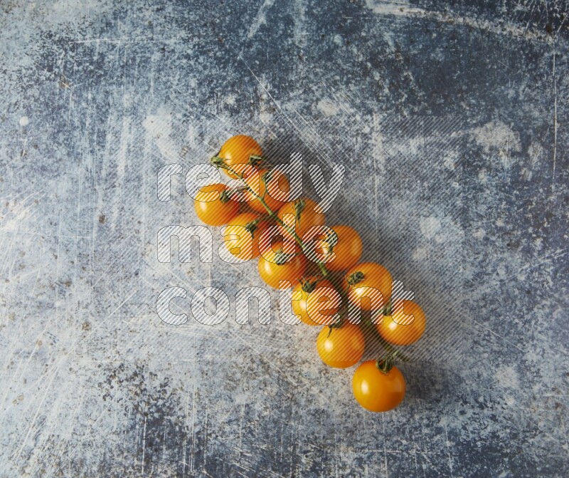 Single cherry tomato vein topview on a rustic blue background